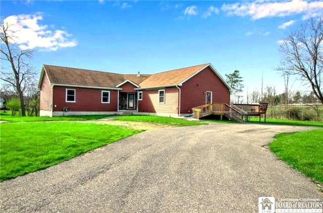 single story home with a front yard, asphalt driveway, and a deck
