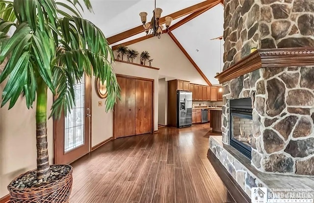 unfurnished living room with high vaulted ceiling, dark wood-type flooring, a stone fireplace, beam ceiling, and baseboards