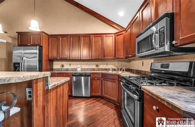 kitchen with stainless steel appliances, a sink, dark wood-style flooring, hanging light fixtures, and lofted ceiling