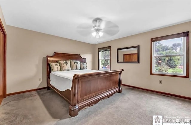 bedroom with light colored carpet, baseboards, and a ceiling fan