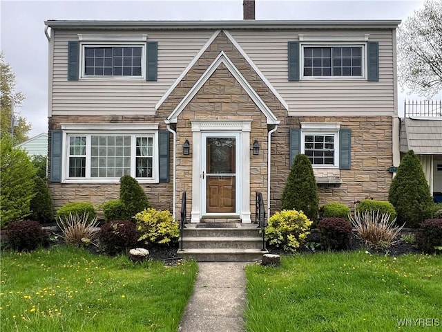 555 Capen Blvd, Amherst, NY 14226 - view of front of house with stone siding, a front lawn, and a chimney