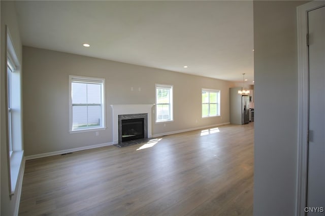522 Chenango Hill Dr, Hamilton, NY 13346 - unfurnished living room with a chandelier, wood finished floors, a premium fireplace, baseboards, and recessed lighting