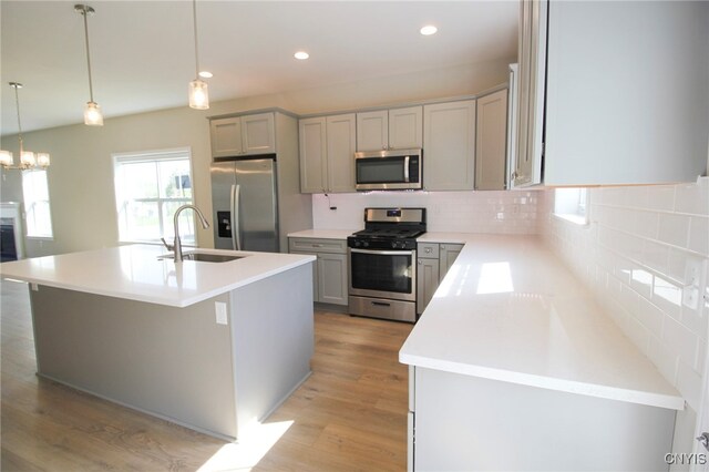 522 Chenango Hill Dr, Hamilton, NY 13346 - kitchen with stainless steel appliances, a sink, decorative backsplash, light wood-style flooring, and gray cabinetry
