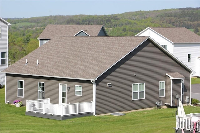 522 Chenango Hill Dr, Hamilton, NY 13346 - rear view of property featuring a wooden deck, a lawn, roof with shingles, and a view of trees