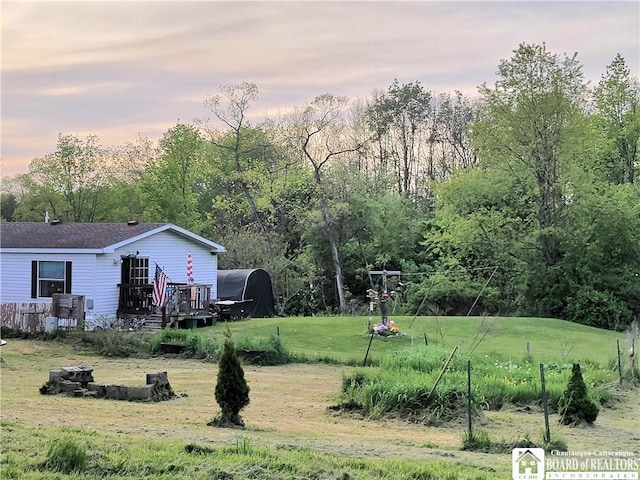 584 Warren Rd, Carroll, NY 14738 - yard at dusk featuring a deck and a lawn
