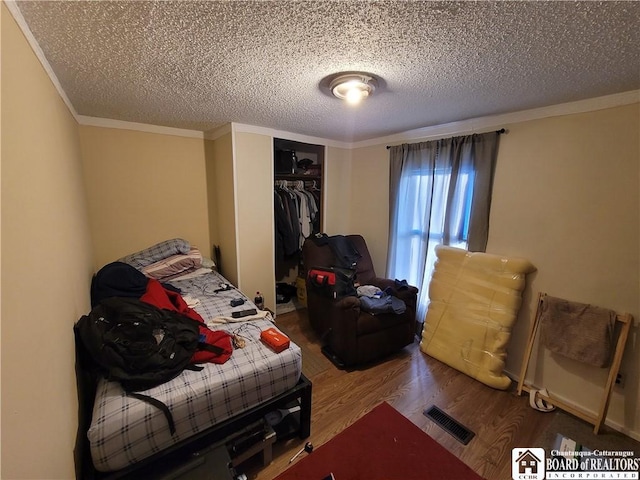 584 Warren Rd, Carroll, NY 14738 - bedroom with wood finished floors, a textured ceiling, crown molding, and a closet