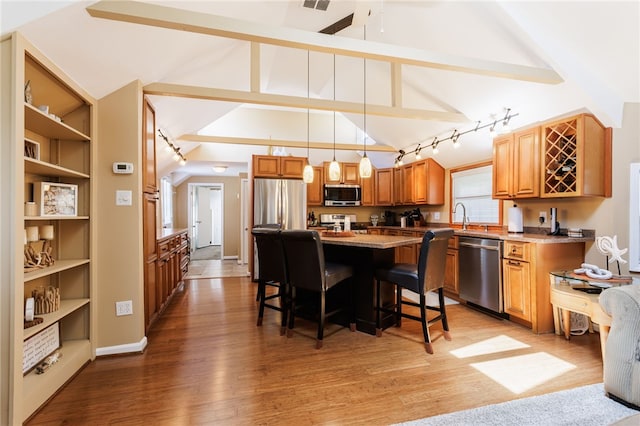 kitchen featuring stainless steel appliances, a breakfast bar area, a kitchen island, and light wood-style floors