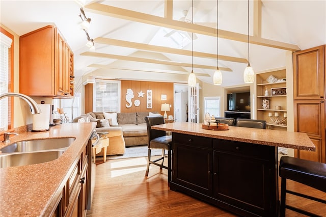 kitchen featuring a kitchen bar, a sink, open floor plan, and healthy amount of natural light