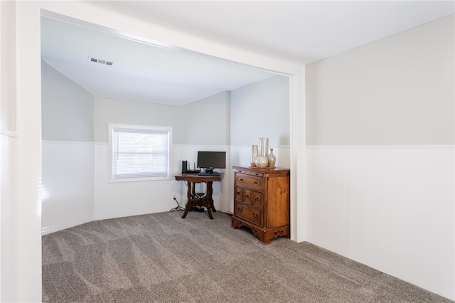 carpeted office space featuring a wainscoted wall