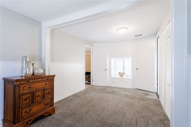 spare room with a wainscoted wall and carpet floors