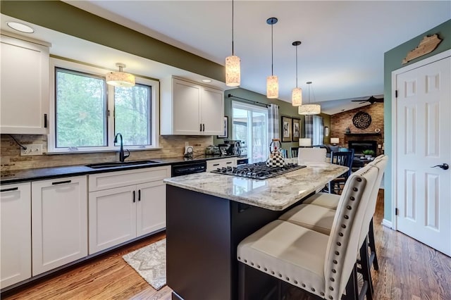 kitchen with a sink, plenty of natural light, stainless steel gas cooktop, and tasteful backsplash