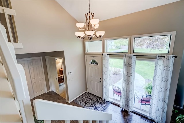 entryway featuring a chandelier, high vaulted ceiling, and tile patterned floors