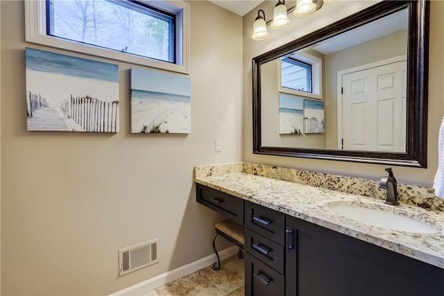 bathroom featuring baseboards, healthy amount of natural light, vanity, and tile patterned flooring