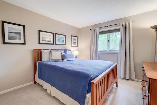 bedroom with light carpet and baseboards