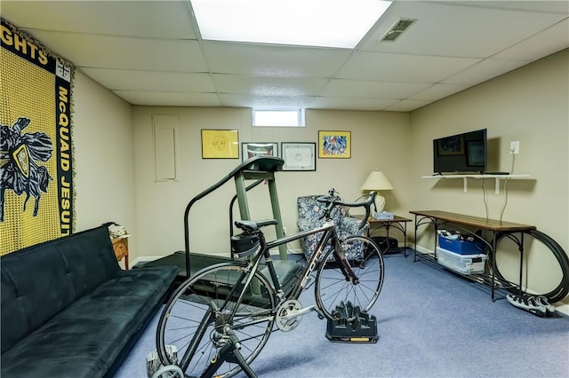 exercise room with a paneled ceiling, carpet floors, and baseboards