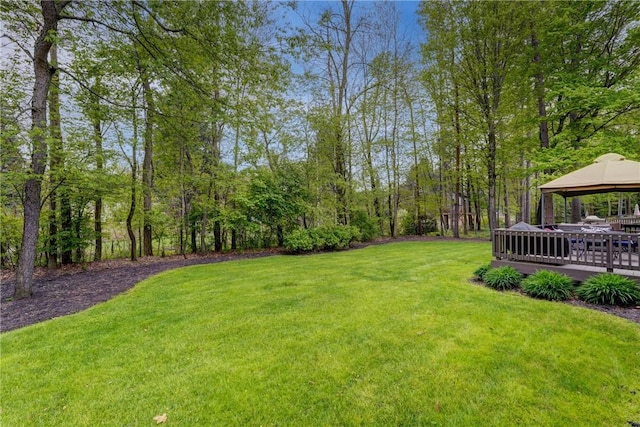 view of grassy yard with a gazebo and a deck
