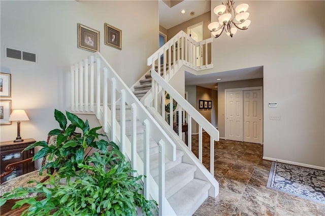 stairs featuring a high ceiling, baseboards, and a chandelier