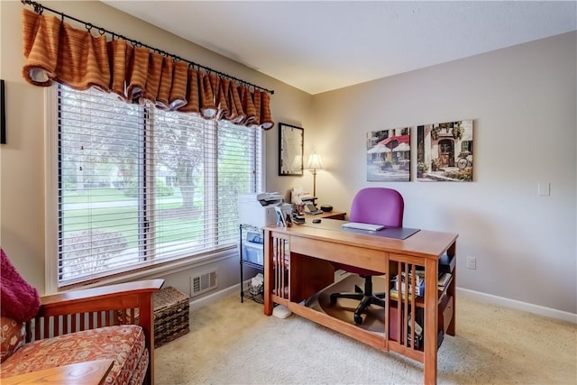 carpeted home office with healthy amount of natural light and baseboards