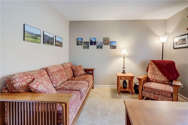 living area featuring light colored carpet and baseboards