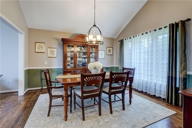 dining area with vaulted ceiling, a chandelier, wood finished floors, and baseboards
