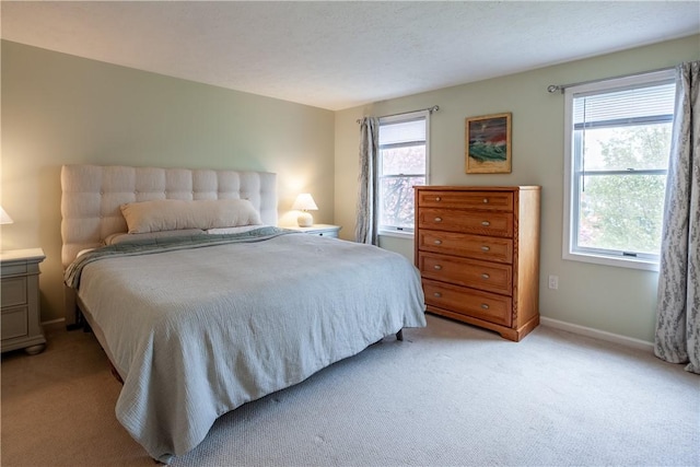 bedroom with light carpet and baseboards