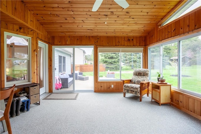 sunroom / solarium with lofted ceiling, carpet flooring, wood walls, and wooden ceiling
