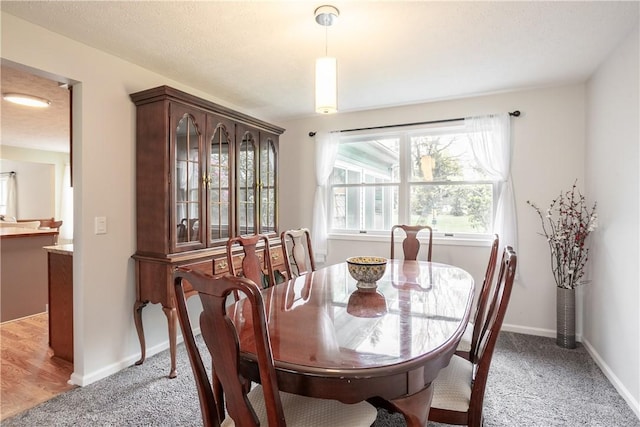 dining room with healthy amount of natural light, light carpet, and baseboards