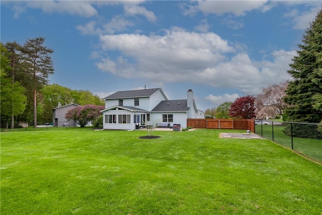 rear view of house with a sunroom, a chimney, and a patio area