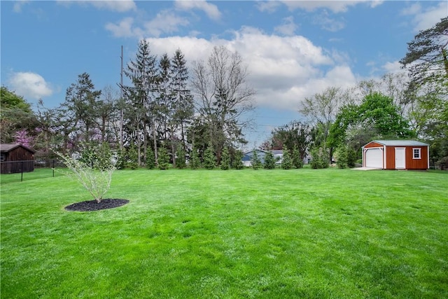 view of yard with a detached garage and an outbuilding