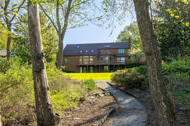 rear view of house with a yard and a wooden deck