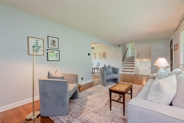 living area featuring stairway, wood finished floors, and baseboards