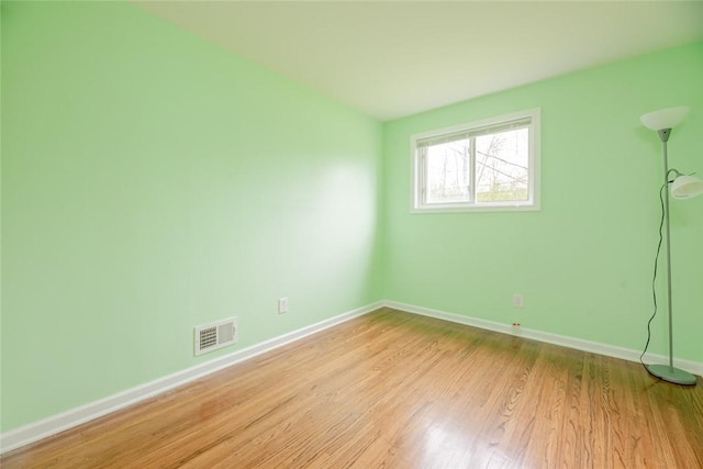 unfurnished room featuring baseboards and light wood-type flooring