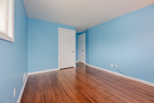 unfurnished room featuring baseboards and wood finished floors