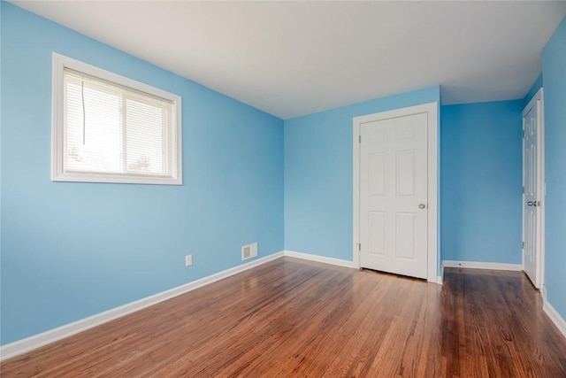 unfurnished bedroom with wood finished floors and baseboards