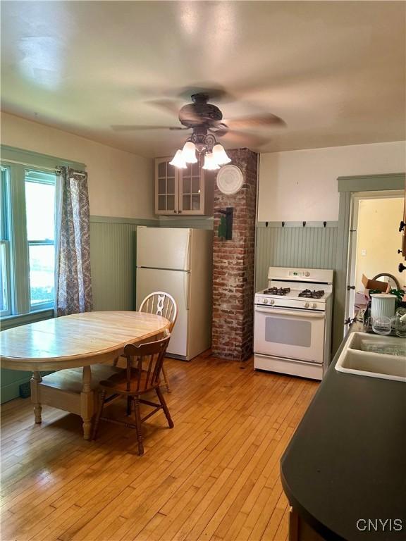 923 Teall Ave, Syracuse, NY 13206 - kitchen with white appliances, wainscoting, a ceiling fan, and light wood-style floors