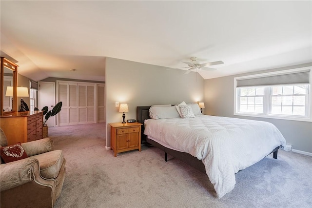 bedroom featuring light colored carpet, lofted ceiling, and a ceiling fan