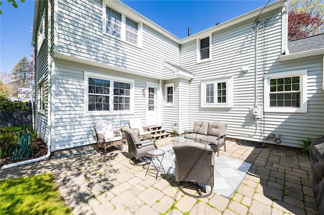 rear view of property with outdoor lounge area, a patio area, and entry steps