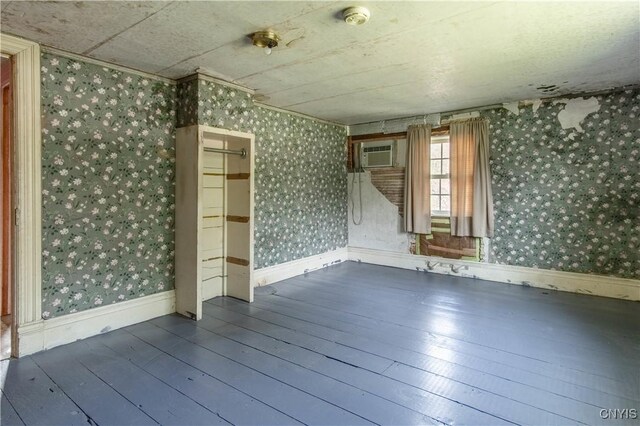 37931 State Route 12e, Clayton, NY 13624 - spare room with wallpapered walls, hardwood / wood-style flooring, a wall mounted air conditioner, and a smoke detector