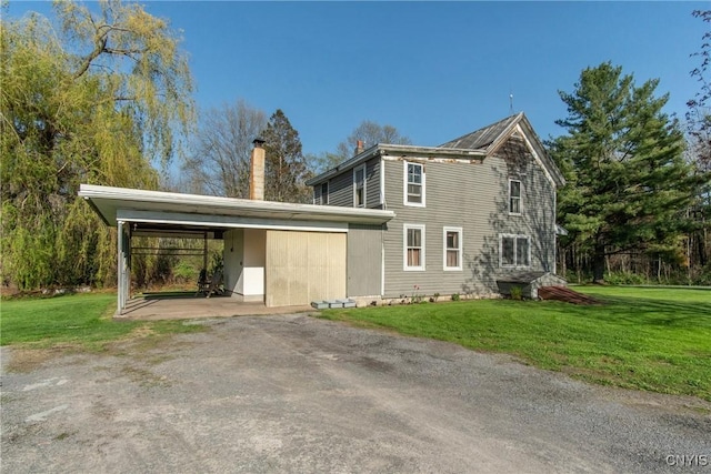 37931 State Route 12e, Clayton, NY 13624 - view of home's exterior with a chimney, a carport, a yard, and driveway