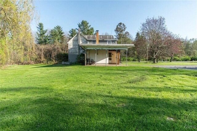 37931 State Route 12e, Clayton, NY 13624 - back of house featuring a yard and a chimney