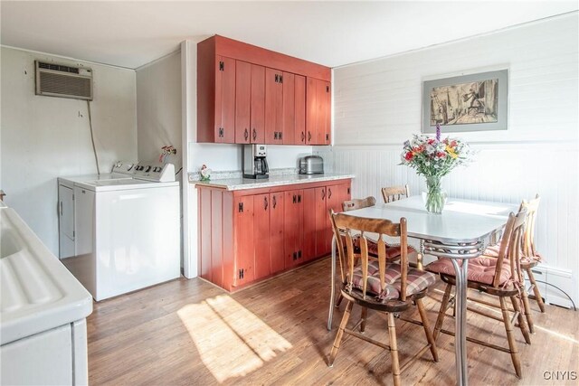 37931 State Route 12e, Clayton, NY 13624 - kitchen featuring washing machine and dryer, light wood-style flooring, light countertops, a wall mounted air conditioner, and a sink