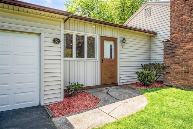 view of exterior entry featuring an attached garage and board and batten siding