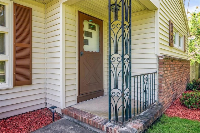 entrance to property featuring brick siding and a porch