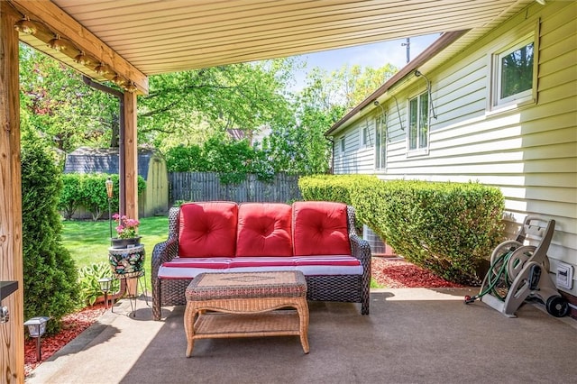 view of patio / terrace featuring an outdoor hangout area, a fenced backyard, a storage unit, and an outdoor structure