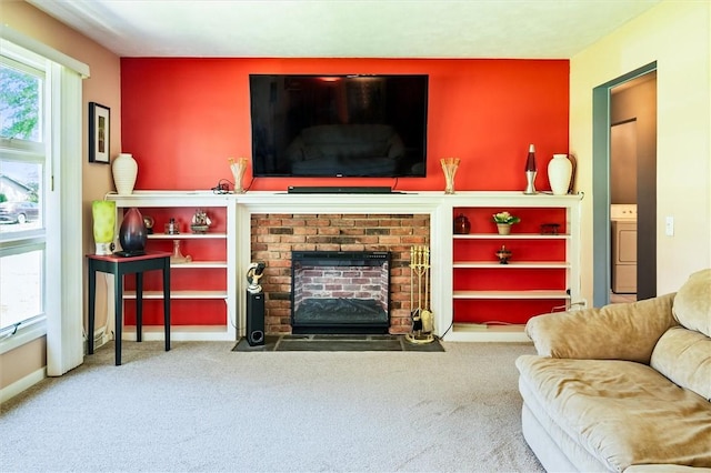 carpeted living room featuring washer / dryer, a fireplace, and baseboards