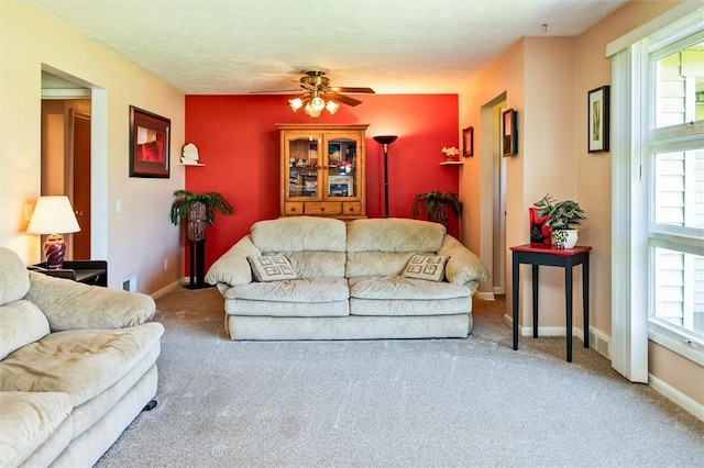 living area featuring carpet, ceiling fan, plenty of natural light, and baseboards