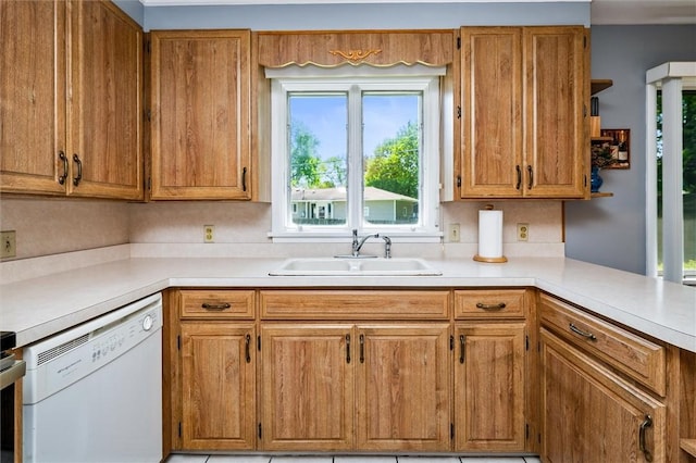 kitchen featuring white dishwasher, a sink, light countertops, and brown cabinetry