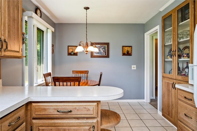 dining room featuring a chandelier, light tile patterned floors, and baseboards