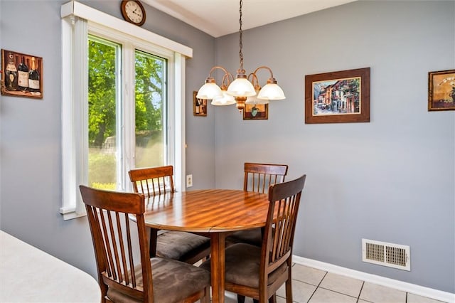 dining room with a chandelier, light tile patterned floors, and baseboards