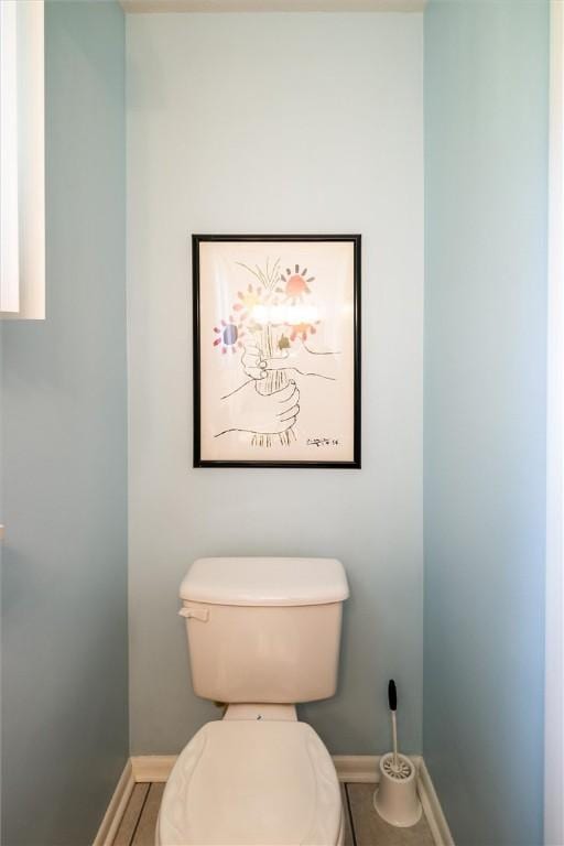 bathroom featuring baseboards, toilet, and tile patterned flooring